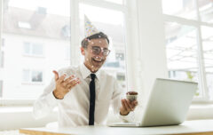 Laughing Businessman With Laptop Celebrating Birthday In Office